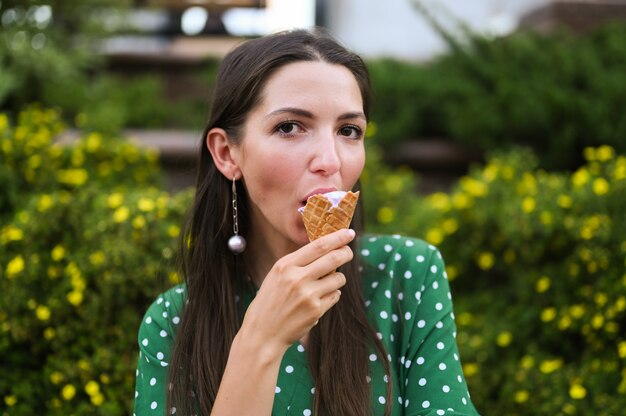 Foto niña come helado en la calle