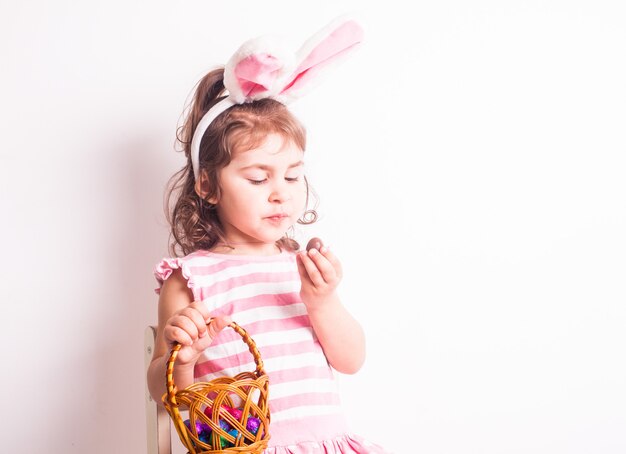 Niña come huevos de chocolate después de la caza de Pascua