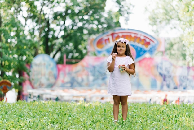 Niña come palomitas de maíz en un parque de diversiones en vacaciones de verano