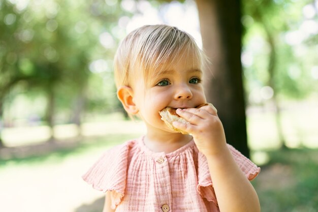 Niña come panqueques en un césped verde