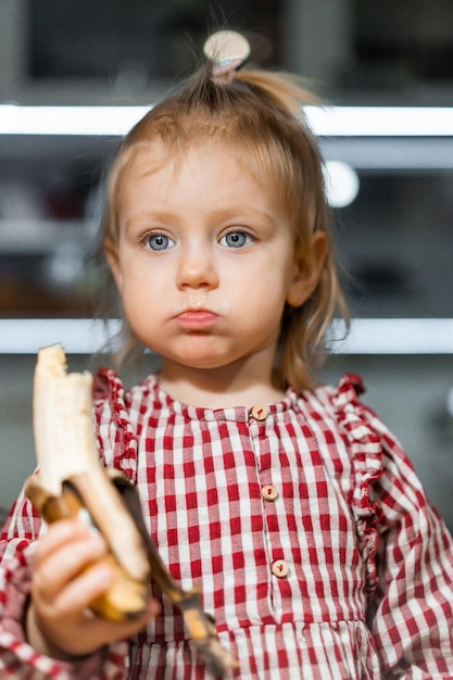 Niña come un plátano Comida para niños