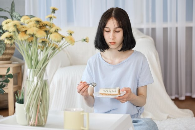 Una niña come postre en la sala de estar.