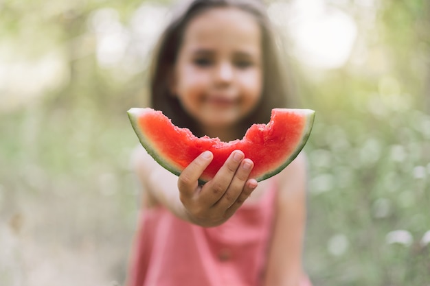 La niña come una sandía. Estado de ánimo de verano de la infancia.