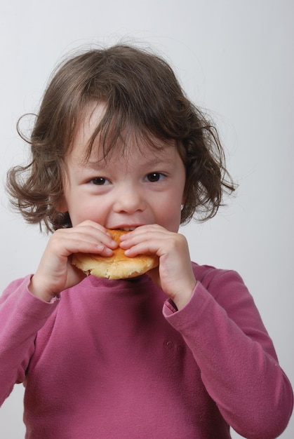 Una niña comiendo un bollo