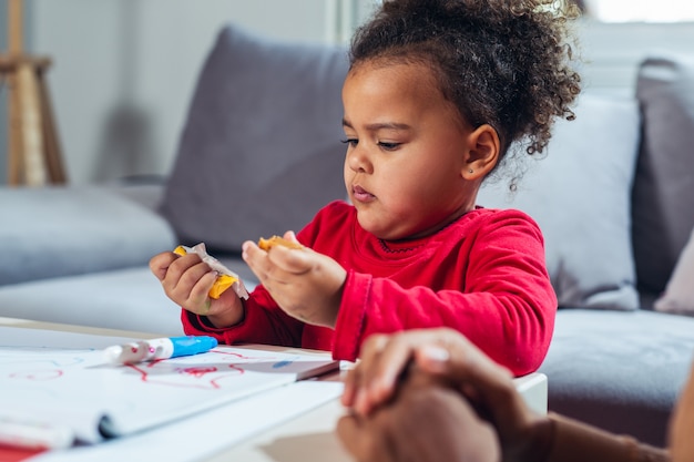 Niña comiendo dulces en casa