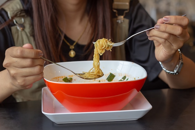 Niña comiendo fideos, almuerzo rápido, fideos Tom Yum