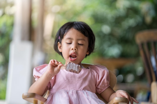 Una niña comiendo un helado de chocolate