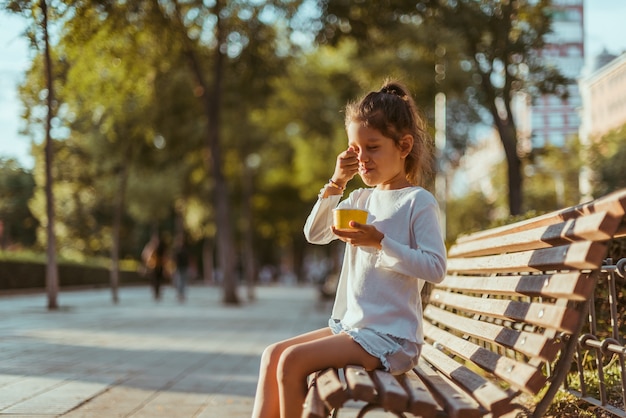 Niña comiendo helado en el parque