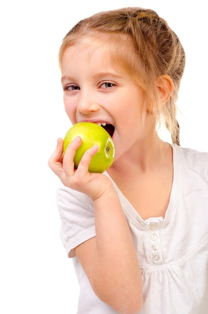 Niña comiendo manzana aislado sobre un fondo blanco.