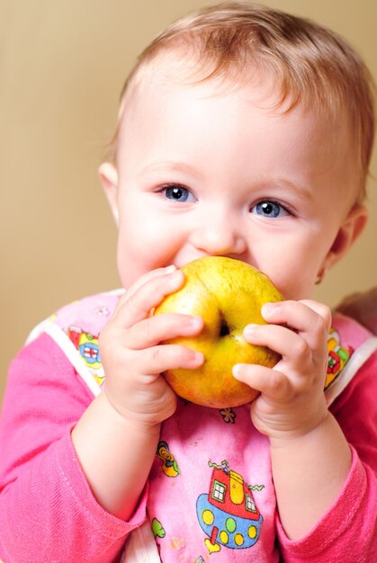 Niña comiendo una manzana y sonriendo