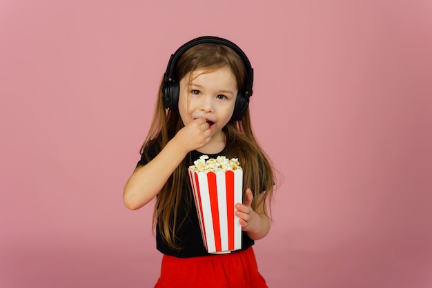 Niña comiendo palomitas de maíz usando