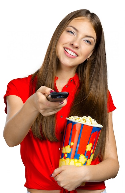 Foto niña comiendo palomitas de maíz y viendo televisión