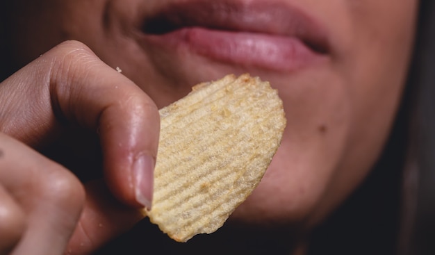 Una niña comiendo una papa frita en fotografía macro
