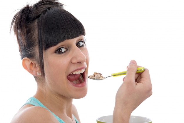 Niña comiendo tazón de cereal de desayuno saludable