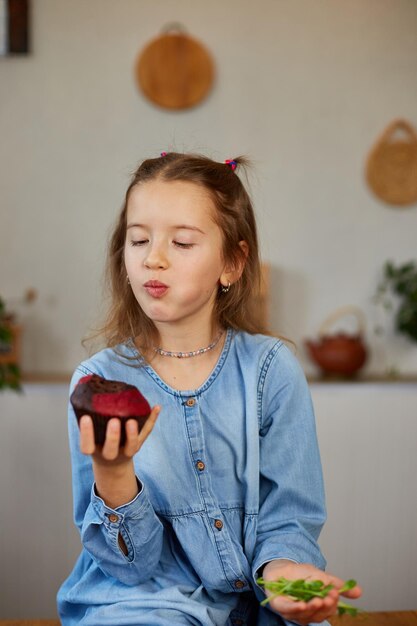 Niña comparando alimentos eligiendo pastel dulce contra hábito insalubre microverde