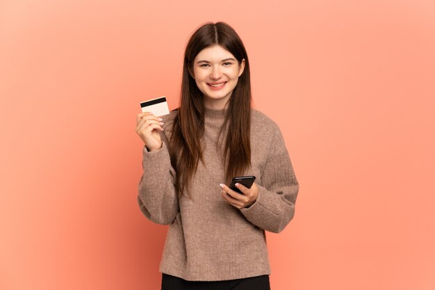 Niña comprando con el móvil con tarjeta de crédito