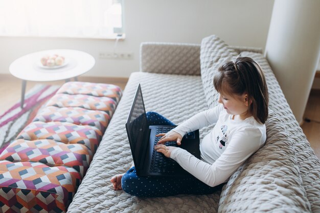 Niña con computadora en casa