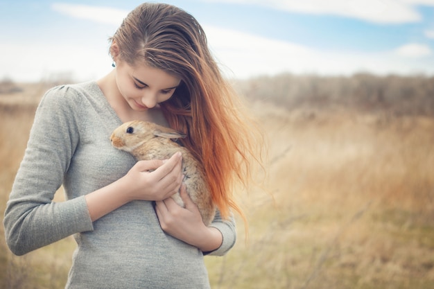 La niña con el conejito. Niña feliz con un lindo conejito esponjoso