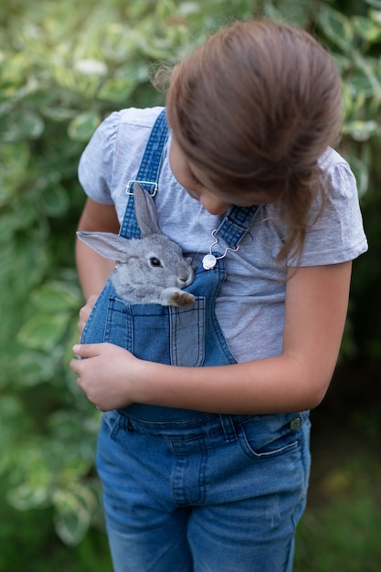 Una niña con un conejo en sus manos.