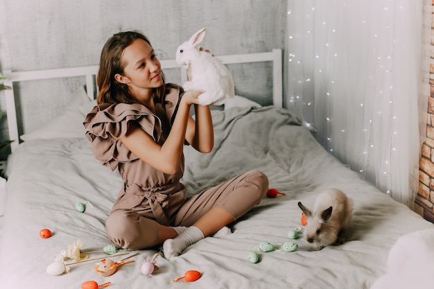 Niña y conejos. Símbolos de Pascua, conejitos de mascotas. Foto de alta calidad