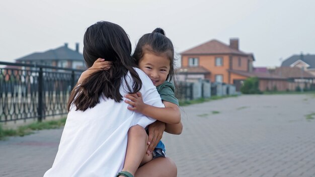 Niña coreana corre y salta en los brazos de la madre en el terraplén