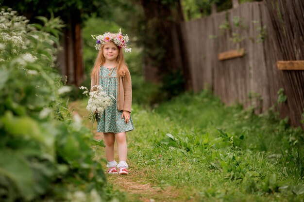 Niña con una corona de flores en la cabeza para pasear