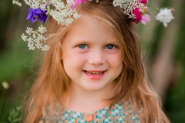 Niña con una corona de flores en la cabeza para pasear