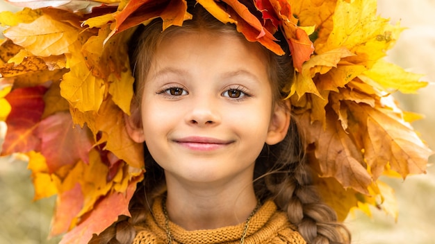 Una niña con una corona de otoño en la cabeza.