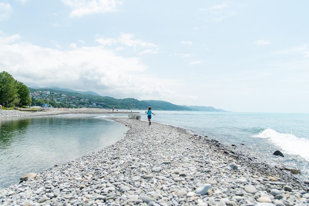 Una niña corre por la playa Verano