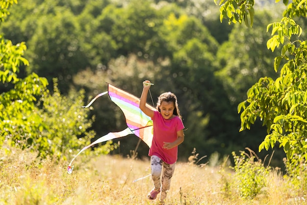 niña corriendo al aire libre con una cometa