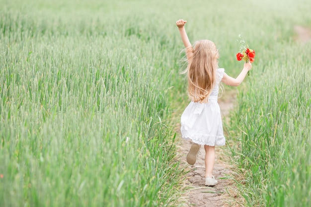 Niña corriendo en el campo del país en verano