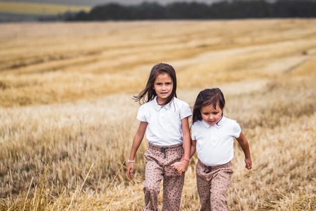 Niña corriendo por el campo soleado.