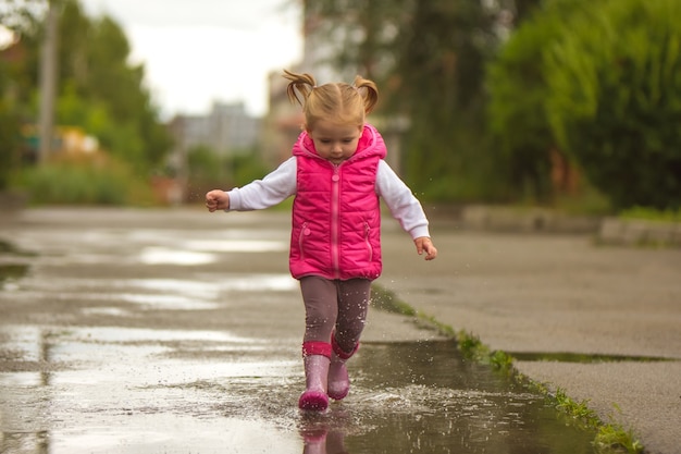 La niña corriendo por un charco