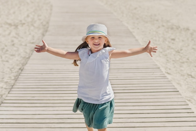 Niña corriendo en la playa del océano