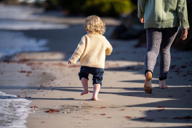 Niña corriendo en la playa a la orilla del mar en verano