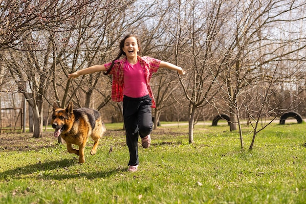 niña corriendo con su mascota pastor alemán.