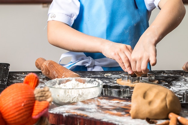 Foto niña cortando galletas de masa de pan de jengibre