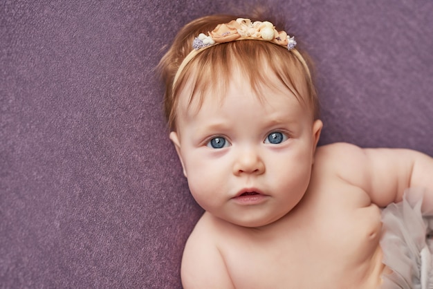 Niña de cuatro meses se encuentra en una pared morada