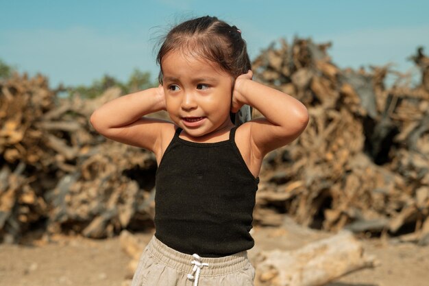 Niña se cubre las orejas debido a la contaminación ambiental