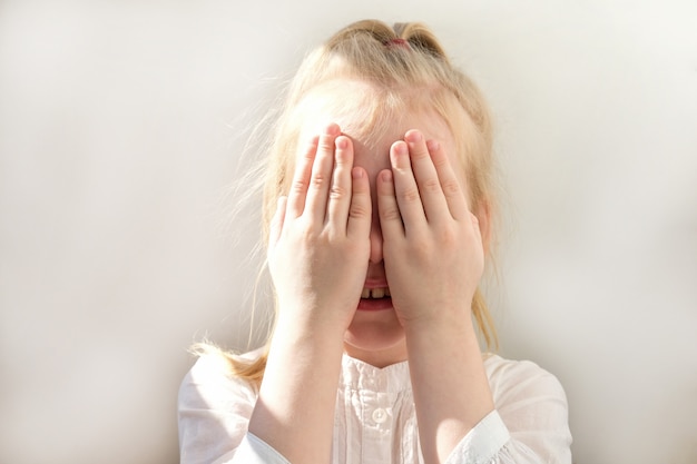 La niña se cubrió la cara con las manos.