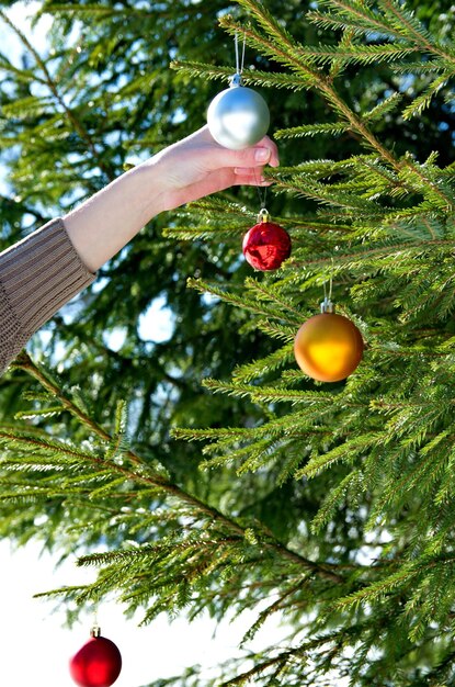 Una niña cuelga bolas de Navidad en el árbol de Navidad. Fondo de año nuevo.