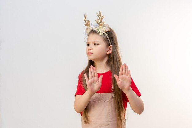 Una niña con cuernos navideños de renos rechaza un regalo.