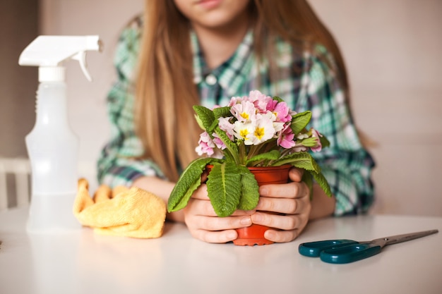 Niña cuida las plantas en su casa, primer plano