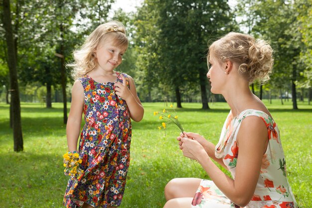 Niña le da flores a una madre