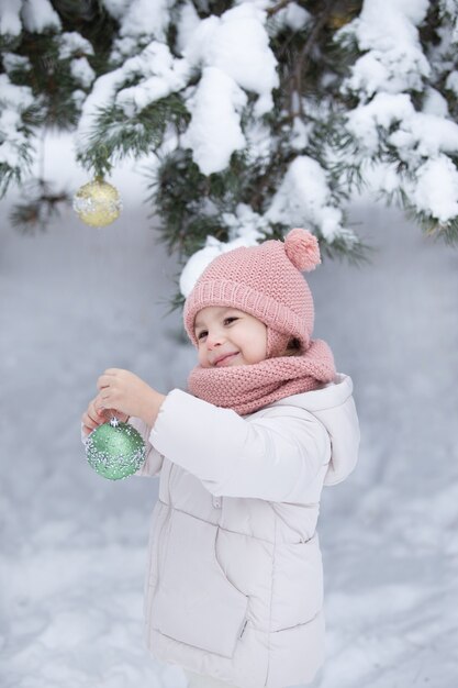 Niña decora el árbol de invierno