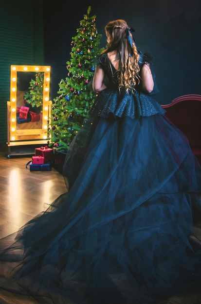 Niña decora un árbol de Navidad por la noche. Enfoque selectivo. Fiesta.