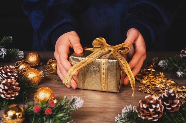 Niña decora regalos de Navidad Vista superior en el fondo de la mesa de madera Celebrar la Navidad