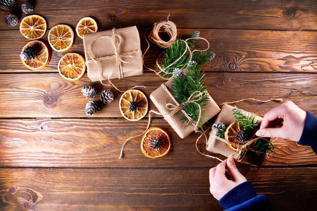 Foto niña decora regalos de navidad vista superior del fondo de la mesa de madera con espacio de copia