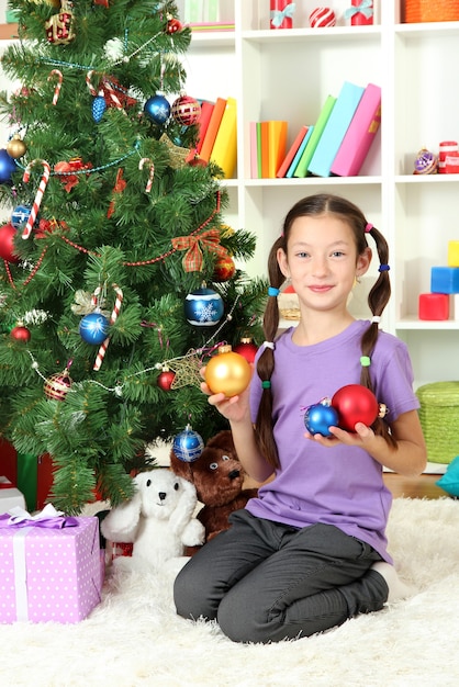 Niña decorando el árbol de navidad