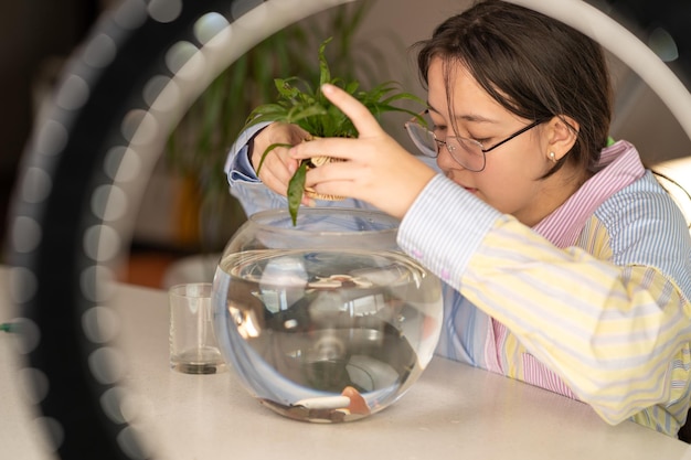 la niña se dedica al diseño del acuario, pone piedras y algas